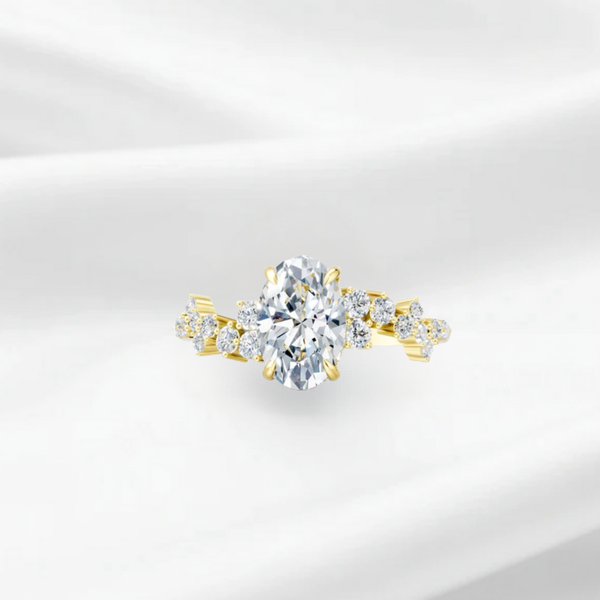 Oval cut diamond engagement ring with an asymmetric scattered diamond cluster band in yellow gold