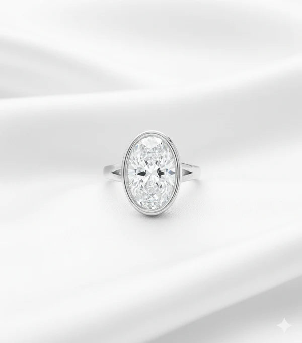 Oval lab diamond engagement ring with bezel setting in white gold featuring a brilliant oval center stone